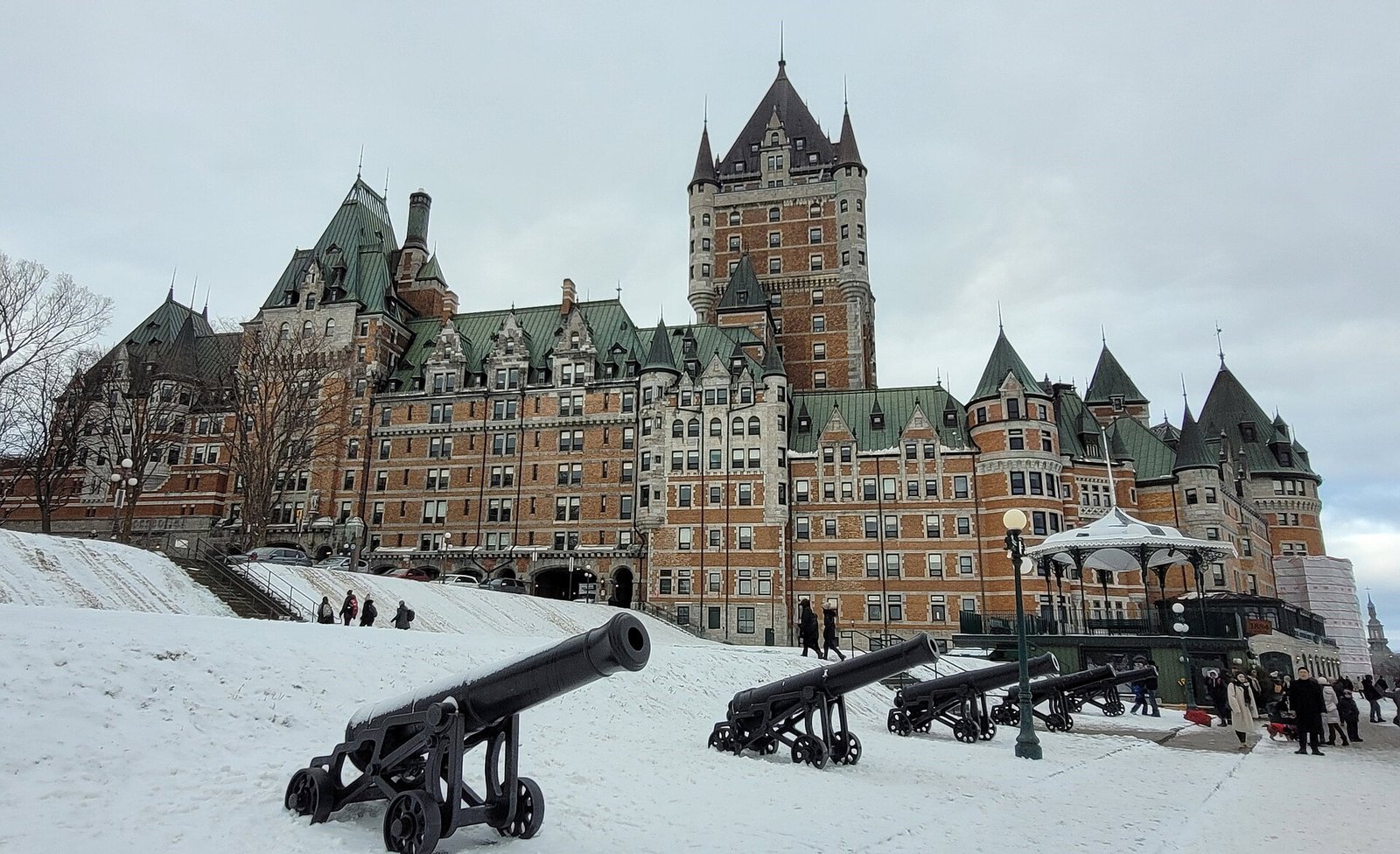 Chateau Frontenac in winter with a row of antique cannons in the snow